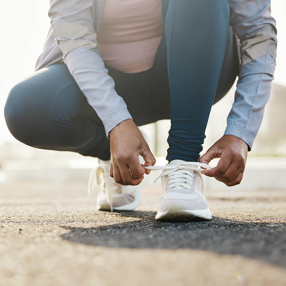 Woman lacing up shoes exercising and staying active.
